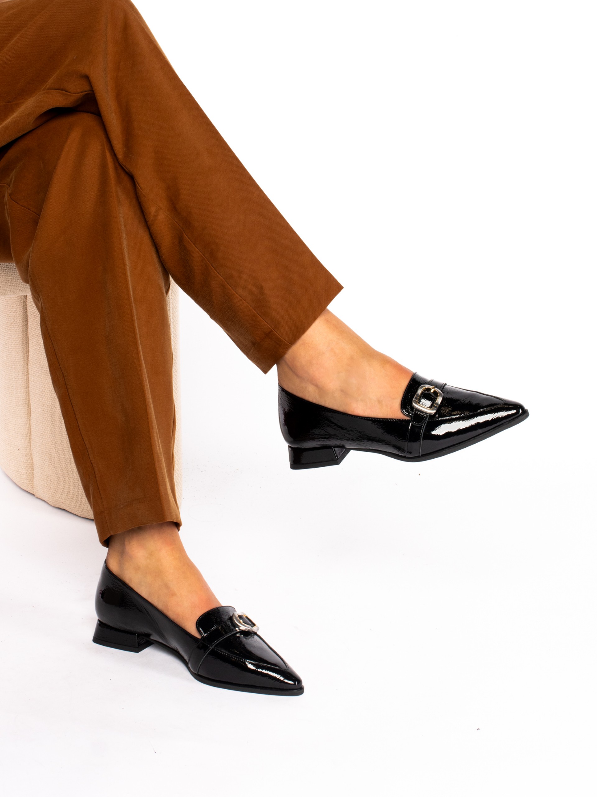 Patent leather shoe with buckle.