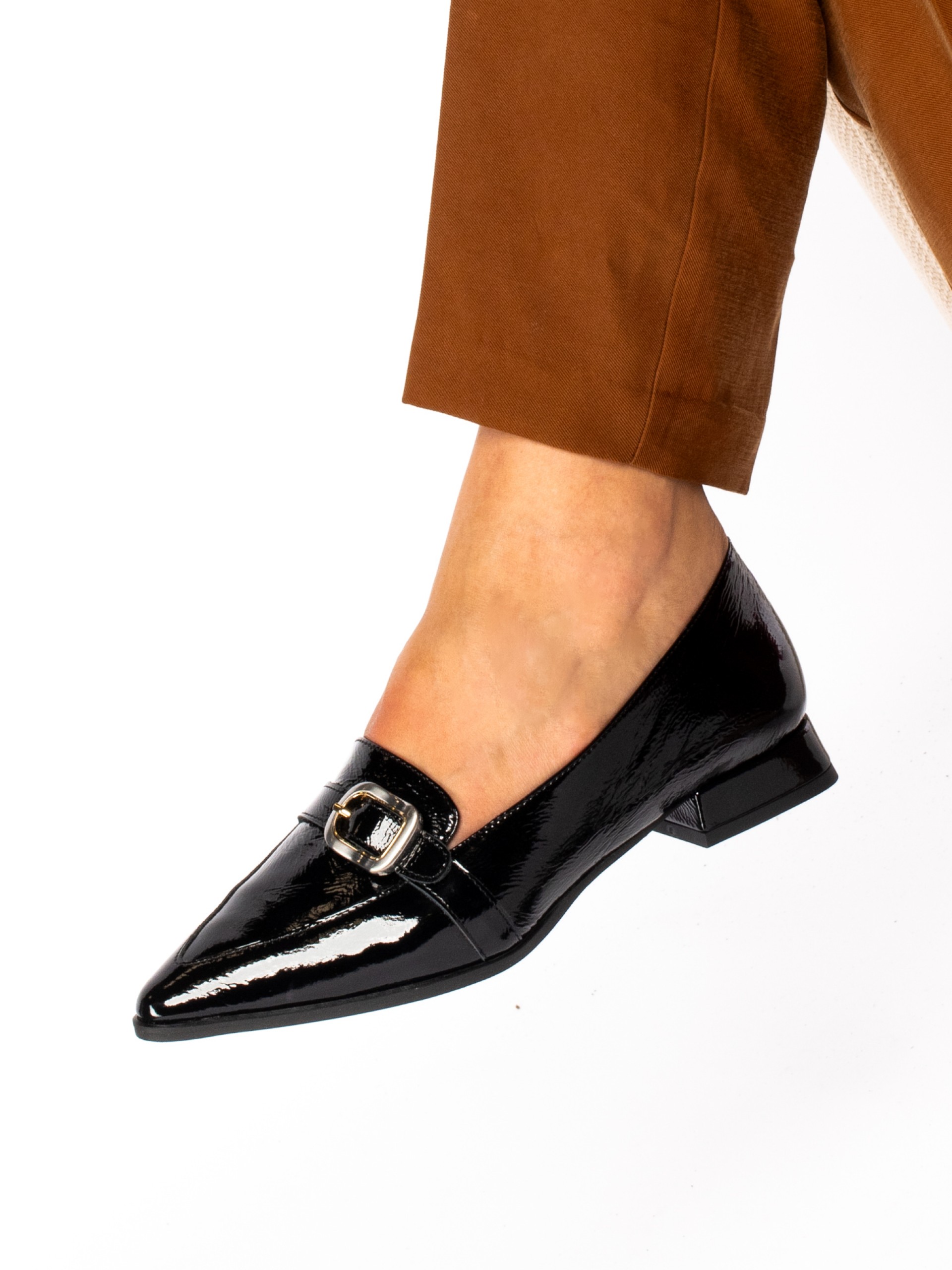 Patent leather shoe with buckle.